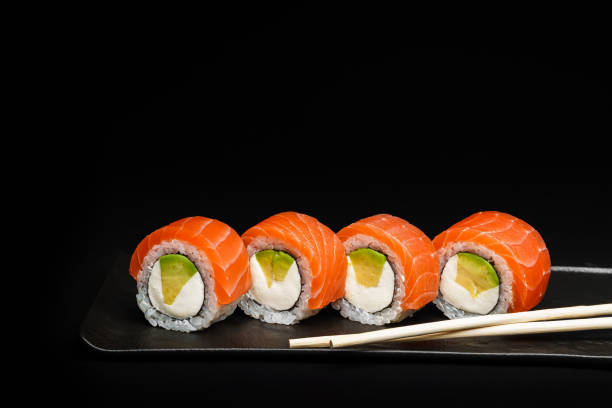 istock Delicious Fresh Salmon Sushi Rolls Presenting Exquisitely on a Black Background 2200609483