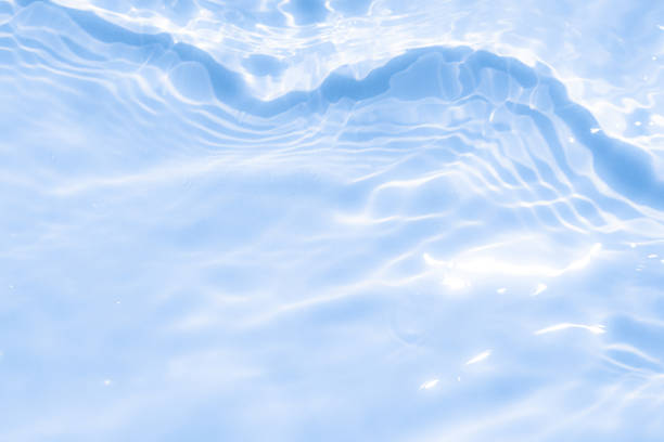 Calm water surface reflecting light creates tranquil ambiance in blue shades during daytime