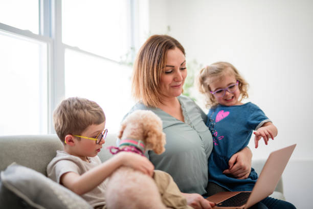 istock mother and her daughters and son portrait sit on sofa with dog at home 2200613607