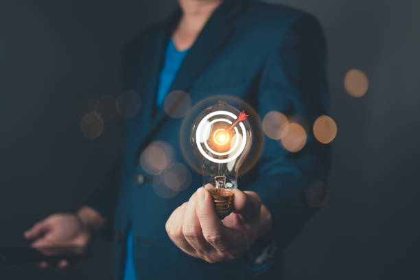 istock A professional hold glowing lightbulb with a target symbol, representing a business goal and strategic plan, showcasing innovation, focus, and determination for success in a competitive environment. 2200614251