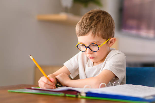 istock homework and school concept - student boy with book writing to notebook at home 2200614430