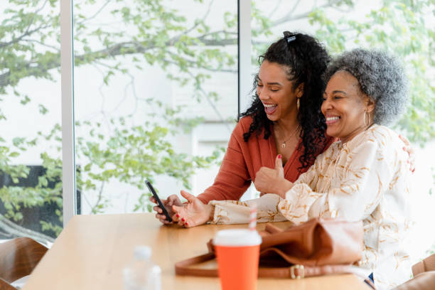 istock Multiracial women looking at smartphone, thumbs up 2200614481