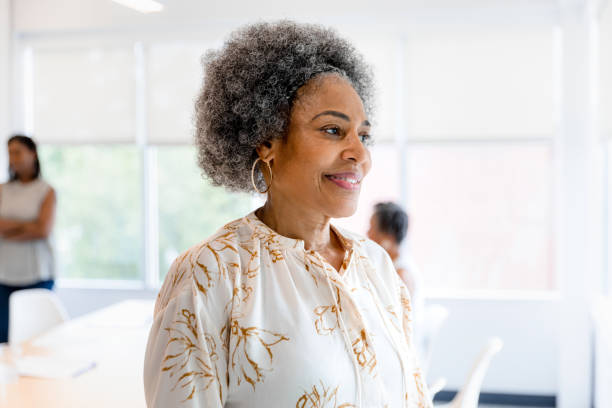 istock Confident Mature Woman Smiling in Office Setting 2200614520