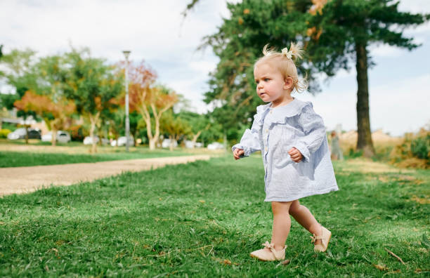 istock Nature, running and child in park for playing, adventure and explore outdoors on weekend. Childhood, summer and toddler girl with cute outfit on grass for freedom, relaxing and fun in playground 2200615042