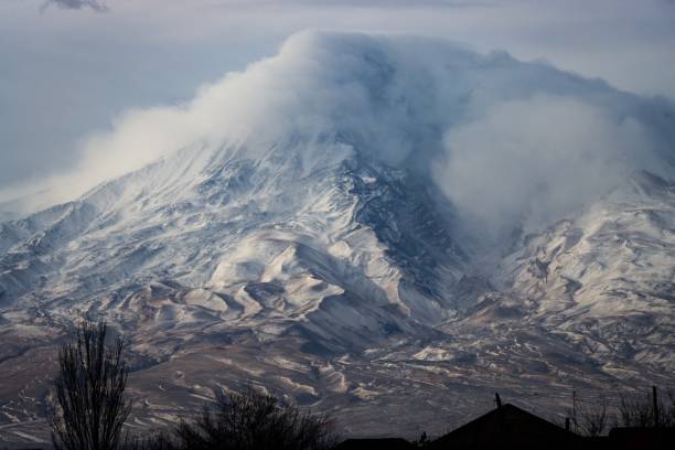 istock Majestic snow-covered mountain peak with clouds. 2200618636