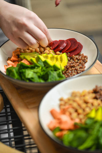 istock Female Adding Final Touches to Balanced Nutritious Salad Bowls 2200620550