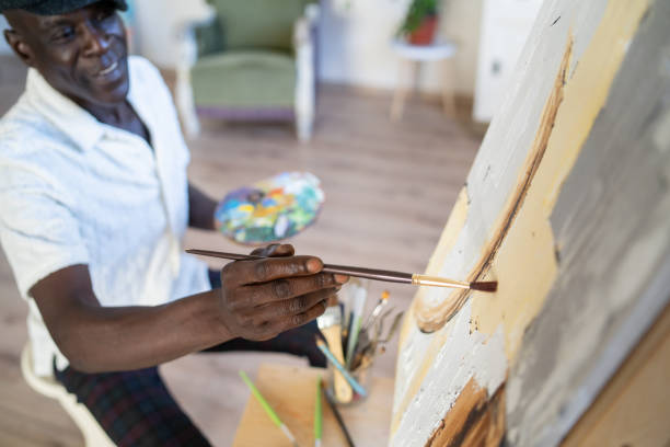 istock Mature man creating a new painting on canvas at home. 2200620971