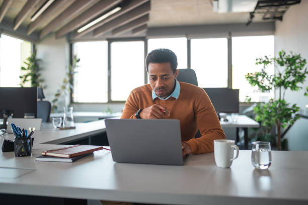 istock Focused Black Businessman Using Laptop in Office 2200621083