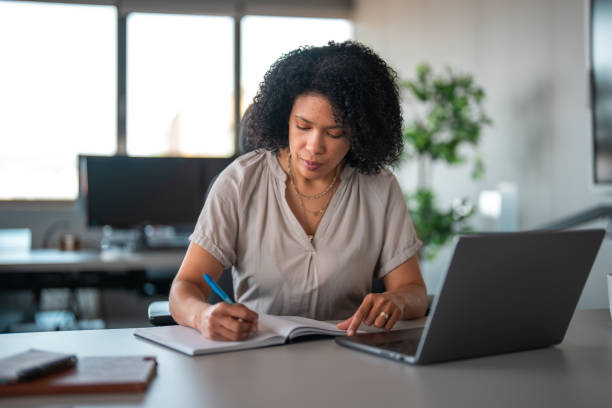 istock Hispanic Businesswoman Engages with Laptop in Office Setting 2200621113