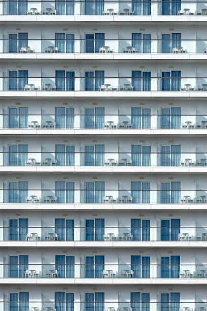 Close-up of building facade with repetitive pattern of curved balconies with railings, showcasing architectural design in Bangkok city, Thailand. Abstract architecture background.