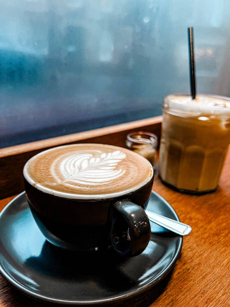 istock Cappuccino With Design On A Wooden Ledge By A Rainy Window 2200627475