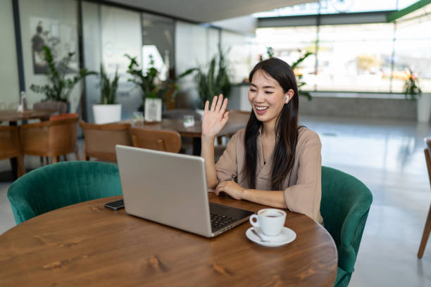 istock Smiling businesswoman talking with client via video call while sitting in cafe 2200631304