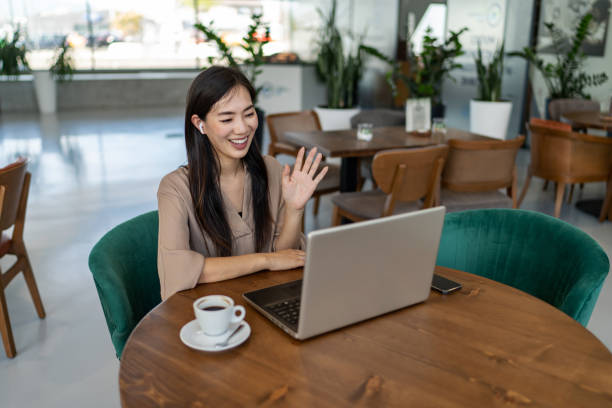 istock Smiling businesswoman talking with client via video call while sitting in cafe 2200631461
