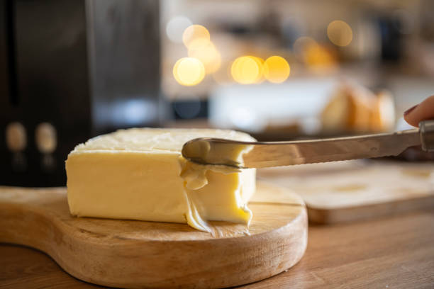 Preparing homemade viral butter board with olive, dried tomato, caper, hard cheese