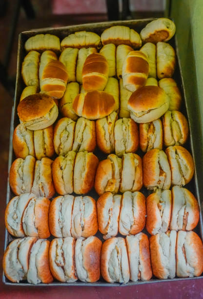 Stock photo of freshly baked Sri Lankan omelette buns sit neatly packed on a bakery tray, ready for serving. The golden, soft buns are perfectly baked, showcasing their fluffy texture and savory filling. This image captures the vibrant flavors of Sri Lankan cuisine