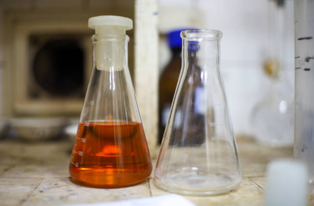 Chemical flask with reagent next to empty one in old laboratory