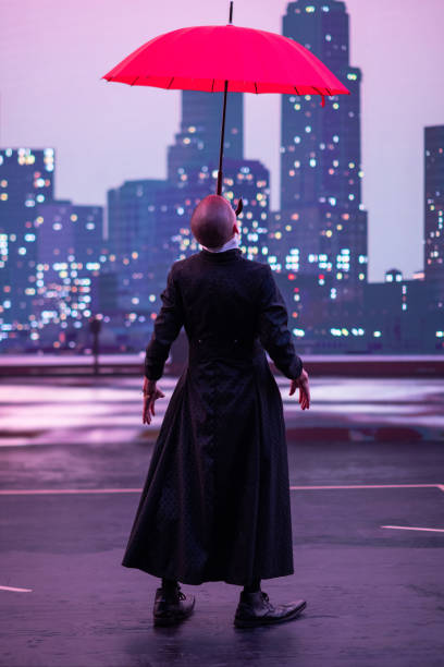 istock Mysterious Clown Performer with Red Umbrella in Urban Nightscape. 2200641631