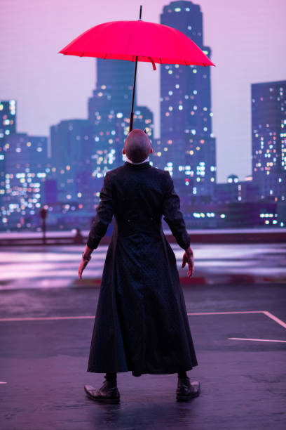 istock Mysterious Clown Performer with Red Umbrella in Urban Nightscape. 2200641828
