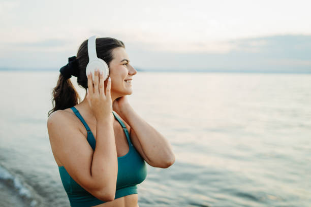 istock Young woman running or jogging on the beach at sunset 2200642724