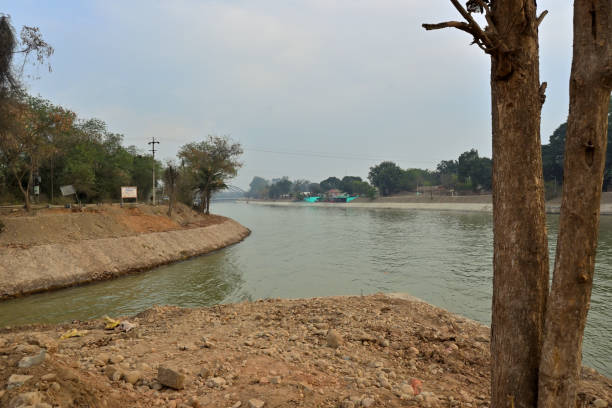 istock A curved river flanked by trees on both banks flows through a landscape. 2200643050