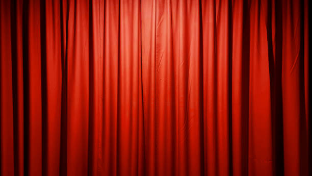istock A luxurious, textured red fabric curtain, draped in soft folds and illuminated with a subtle glow, creates an elegant and versatile background suitable for stage curtains. 2200644897