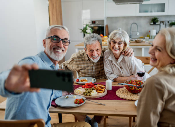 istock Senior friends posing for selfies during their meal 2200645318