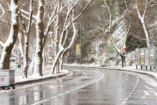 Istanbul, Turkey - March 11, 2022: Heavy snowfall over a Istanbul city street.\nSnow falls intensely, covering the road, sidewalks, and buildings. Advertisement billboards are visible along the street. Snow accumulates unevenly on the pavement. Photo taken on March 11, 2022.