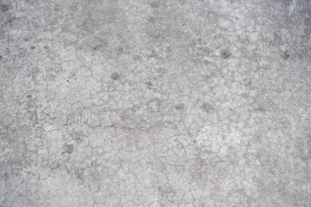 istock Cracked concrete wall covered with gray cement surface. Grey old wall with shabby damaged plaster or cement and brick background of an vintage dirty exfoliating plaster. Mock up. 2200646492