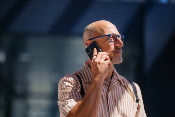 Businessman in Urban Setting Engaged in Phone Conversation in Bright Daylight