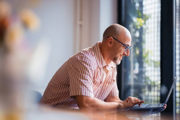 istock Smiling Professional Working on a Laptop in a Bright Home Office Environment 2200646617