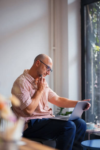Focused Man Working on Laptop in a Bright and Contemporary Workspace