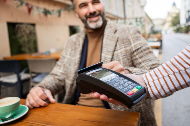 istock Caucasian Male Using A Credit Card In A Cafe 2200646794