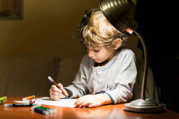 istock Child drawing illuminated by the light of a lamp. 2200648835