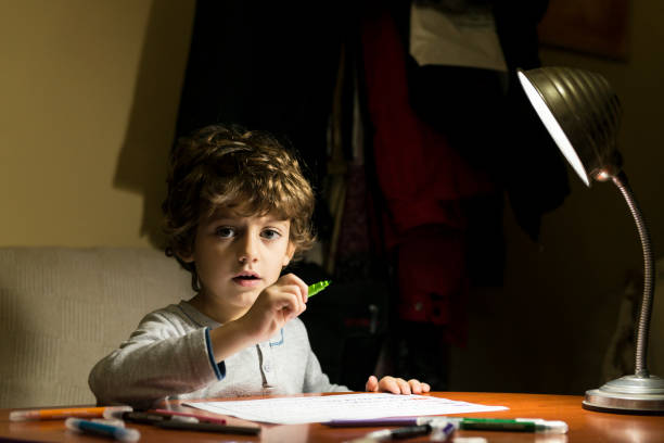 istock Child drawing illuminated by the light of a lamp. 2200648841