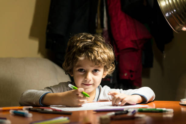istock Child drawing illuminated by the light of a lamp. 2200648854