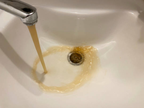 istock Dirty rusty brown polluted water flowing from tap in bathroom sink. Problems with plumbing and rusted pipes. Dirty tap water 2200658082