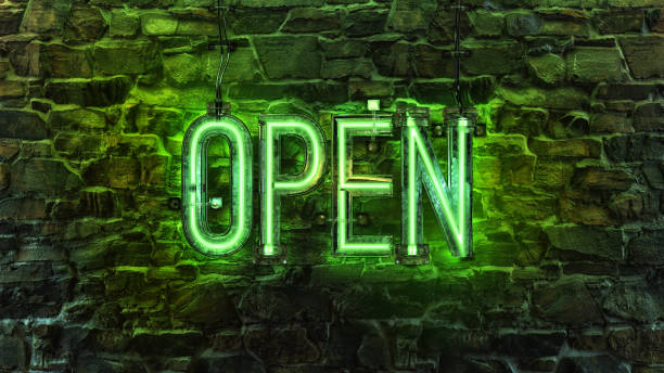 istock OPEN neon sign light billboard in night time. Glowing green neon signboard 2200663712