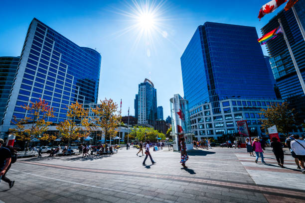 Vancouver, Canada - August 17, 2023: Tourists walking along a modern pedestrian zone between skyscraper in Vancouver.