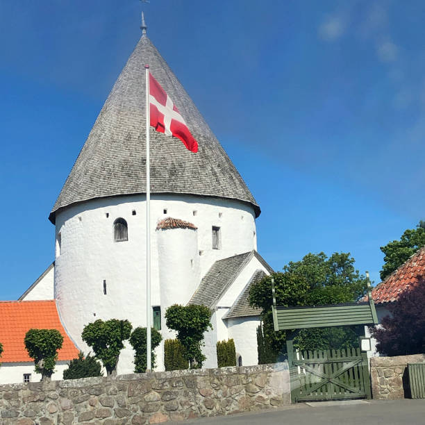 One of the smallest of the roundchurches on Bornholm. Glorius day in june, with the danish flag in the air.