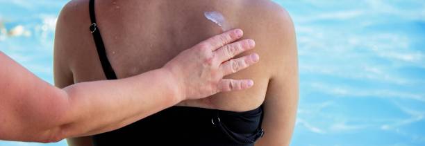 istock Woman applying sunscreen on child's back. Sun protection. 2200665487