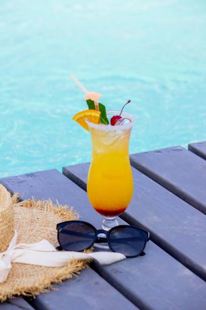 istock A nice cocktail, hat and sunglasses by the pool 2200665515