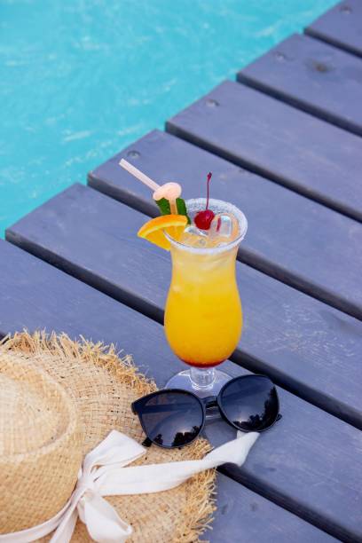 istock A nice cocktail, hat and sunglasses by the pool 2200665521