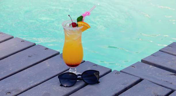 istock A nice cocktail, hat and sunglasses by the pool 2200665531