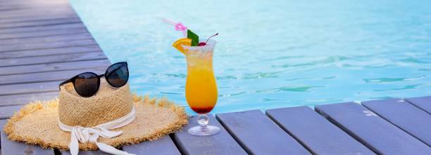 istock A nice cocktail, hat and sunglasses by the pool 2200665559