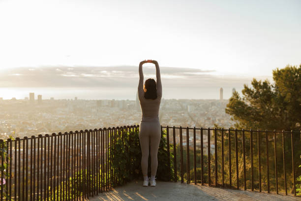 Woman stretching with cityscape view at sunrise