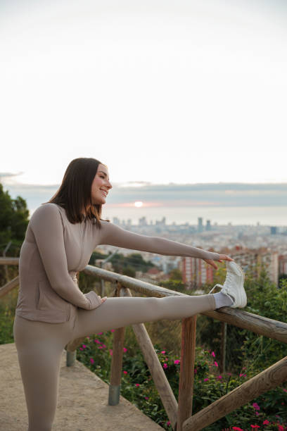 istock Woman stretching outdoors with cityscape view 2200669849