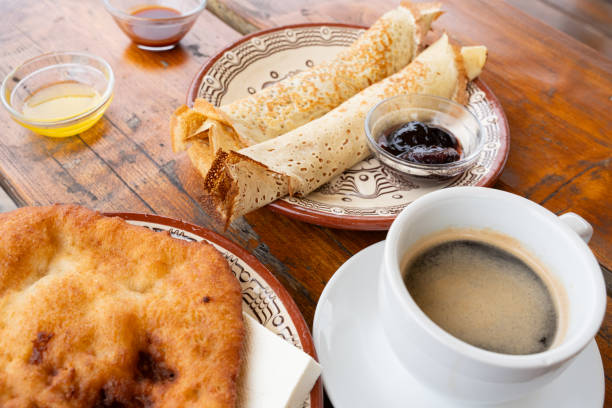 Traditional Bulgarian breakfast with pancakes, jam, honey, mekitsa and coffee, served on a wooden table in a restaurant in the Rodopes mountains