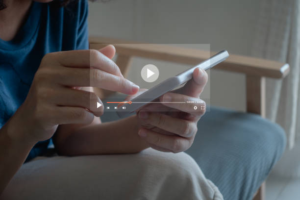 istock Woman touching smartphone to watching and live streaming window for Video streaming on internet and multimedia technology, live video content online streaming marketing concept. 2200684007