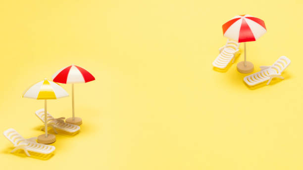 istock Two sun loungers and a red umbrella on a yellow background. 2200684629