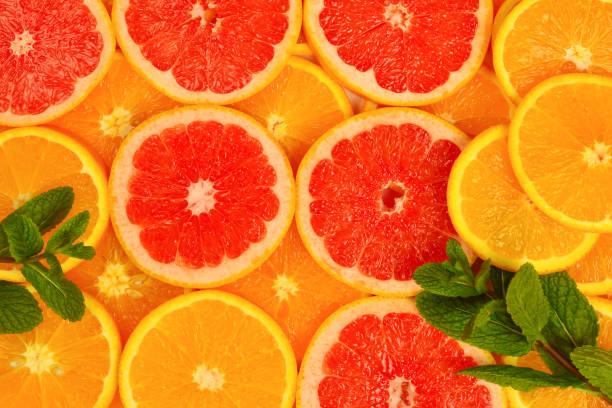 istock Slices of oranges and a grapefruits and mint as a background. 2200684651